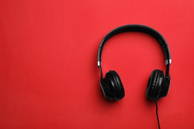 Photo of Stylish modern headphones with earmuffs on color background, top view. Space for text