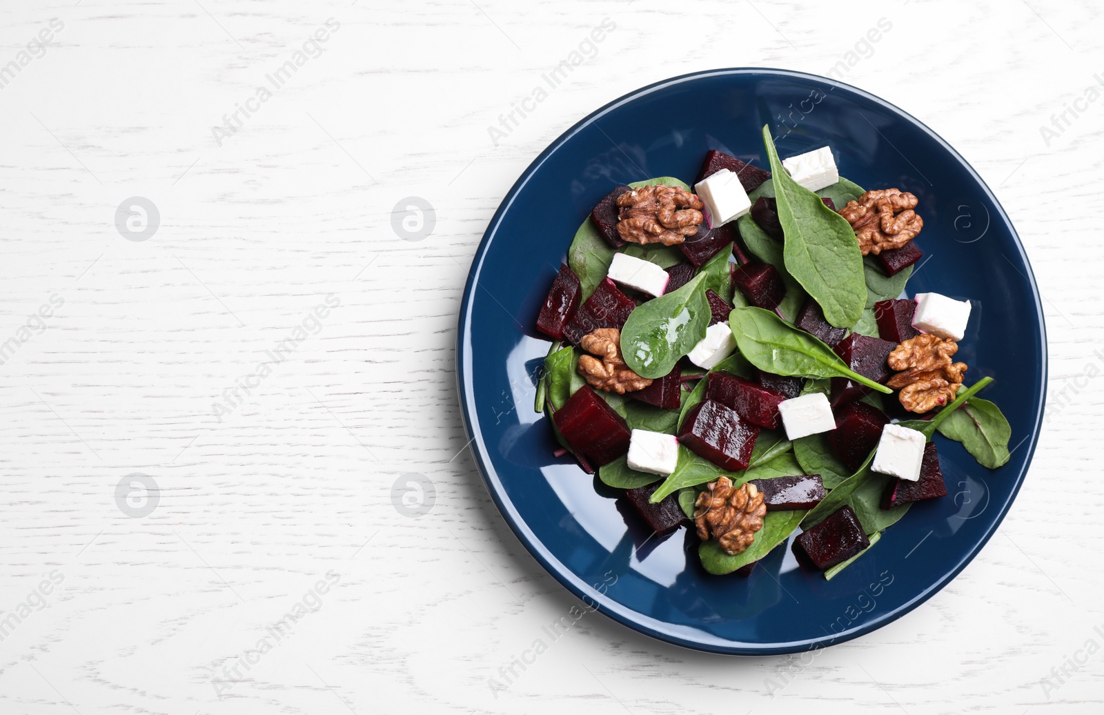 Photo of Fresh delicious beet salad on white wooden table, top view. Space for text