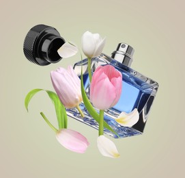Image of Bottle of perfume and tulips in air on beige background
