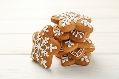 Photo of Tasty Christmas cookies with icing on white wooden table, closeup