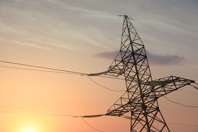 Photo of High voltage tower at sunset, low angle view