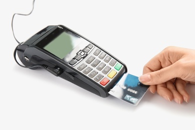 Woman using modern payment terminal on white background, closeup