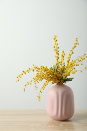 Bouquet of beautiful mimosa flowers on wooden table