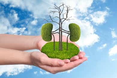 Image of Closeup view of woman with tree in shape of human kidneys against blue sky. Health care concept