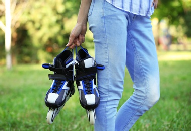 Photo of Woman with roller skates in summer park, closeup