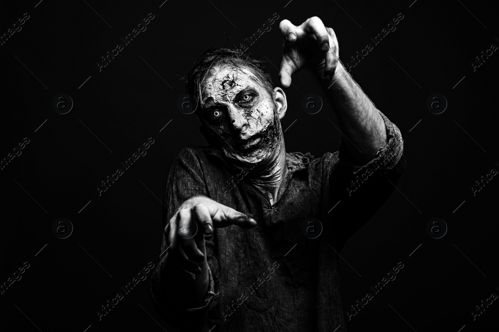 Photo of Scary zombie on dark background, black and white effect. Halloween monster