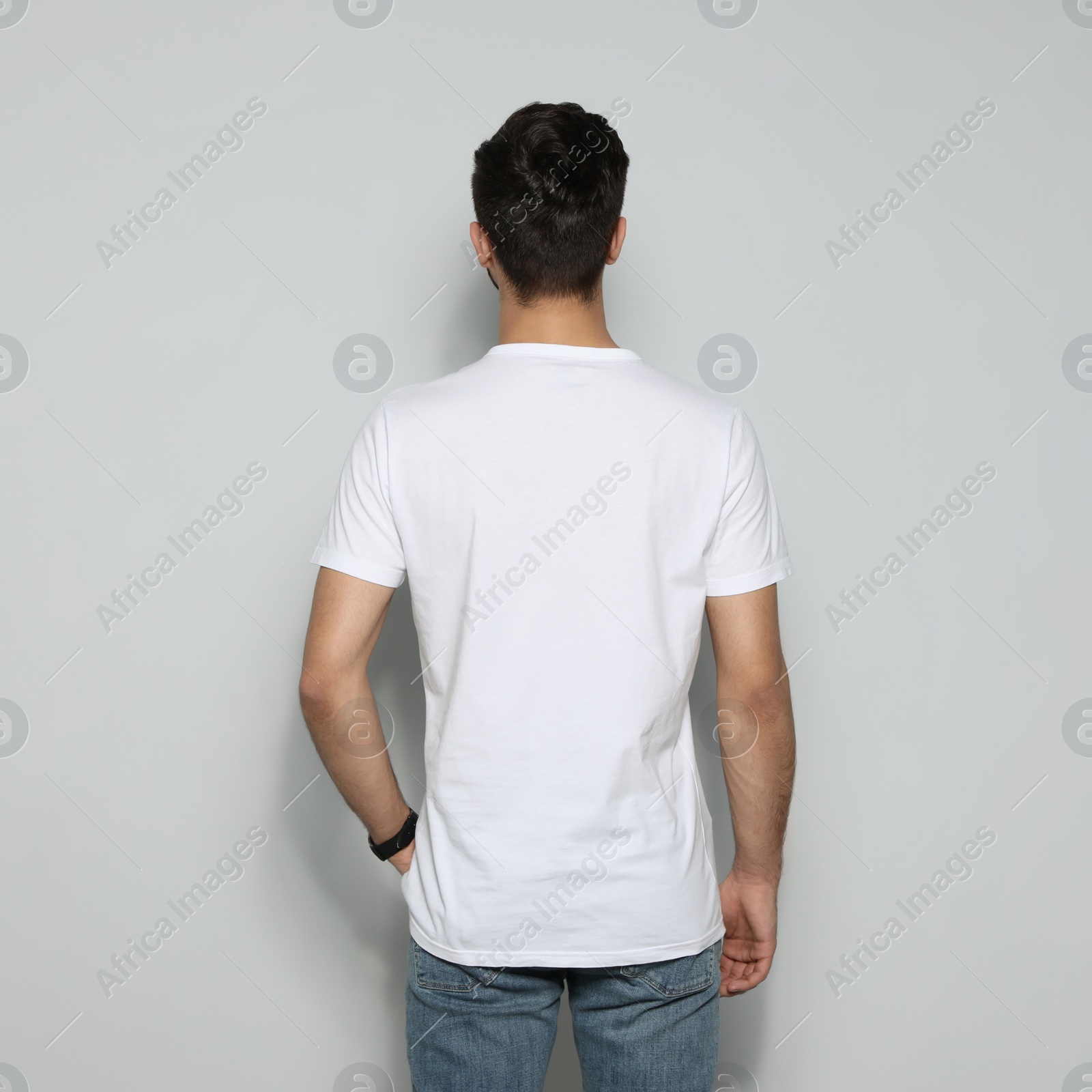 Photo of Young man in t-shirt on light background. Mock up for design