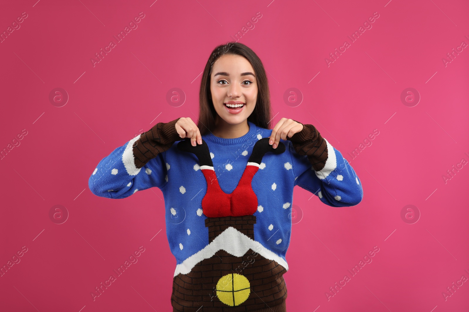 Photo of Young woman in Christmas sweater on pink background