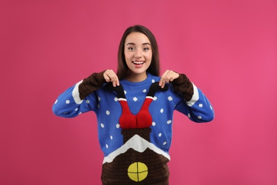Photo of Young woman in Christmas sweater on pink background