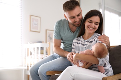 Happy couple with their newborn baby at home