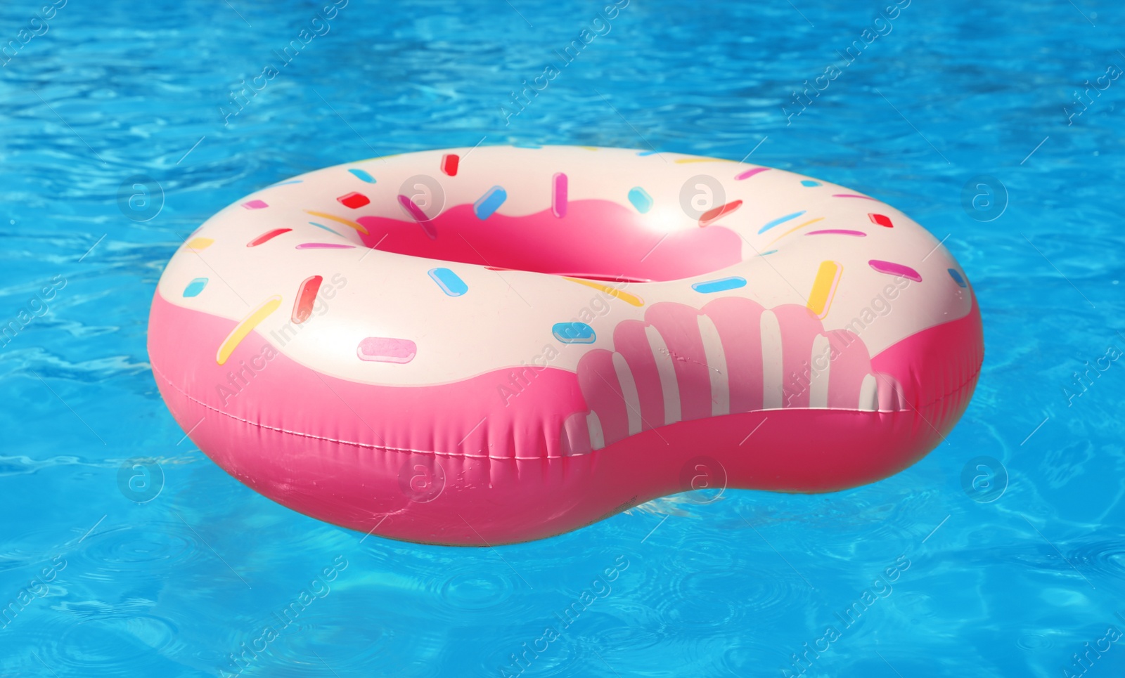 Photo of Inflatable ring floating in swimming pool on sunny day