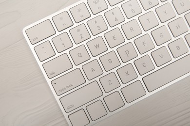Internet shopping. Computer keyboard on light wooden background, top view