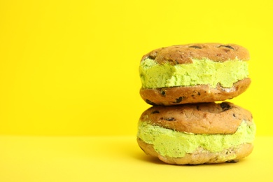 Photo of Sweet delicious ice cream cookie sandwiches on color background, space for text