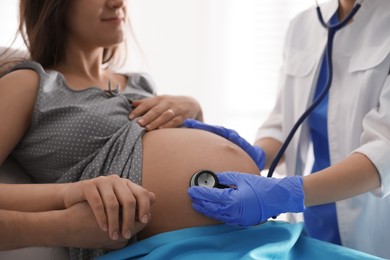 Doctor examining woman before giving child birth in maternity hospital, closeup