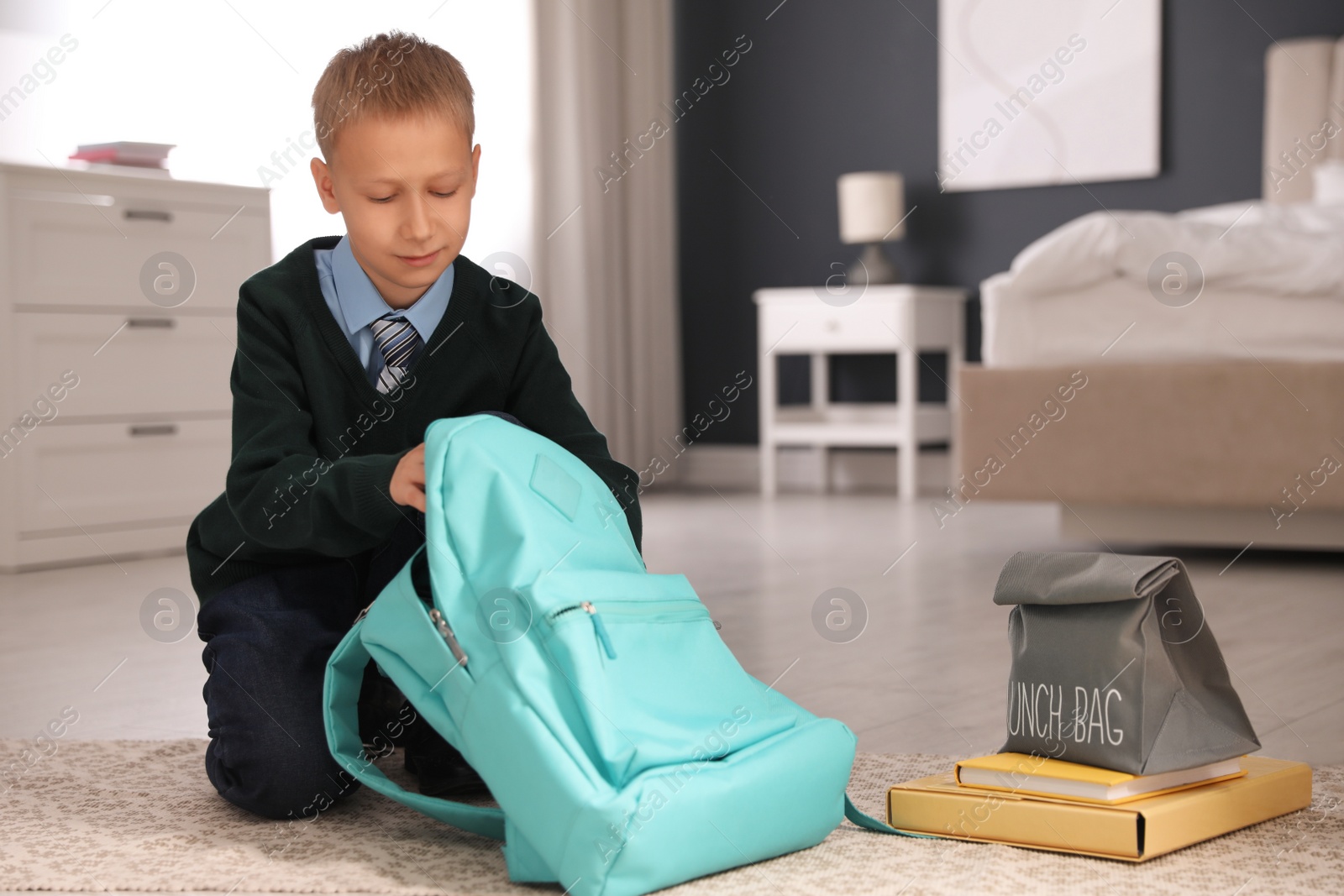 Photo of Little boy getting ready for school in bedroom