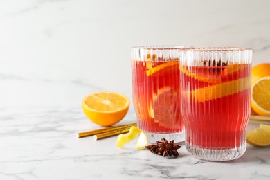 Photo of Aromatic punch drink and ingredients on white marble table. Space for text