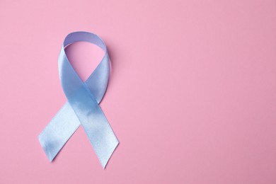 International Psoriasis Day. Light blue ribbon as symbol of support on pink background, top view. Space for text