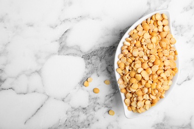 Photo of Plate with dried peas on marble background, top view