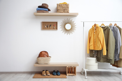 Hallway interior with stylish furniture, clothes and accessories
