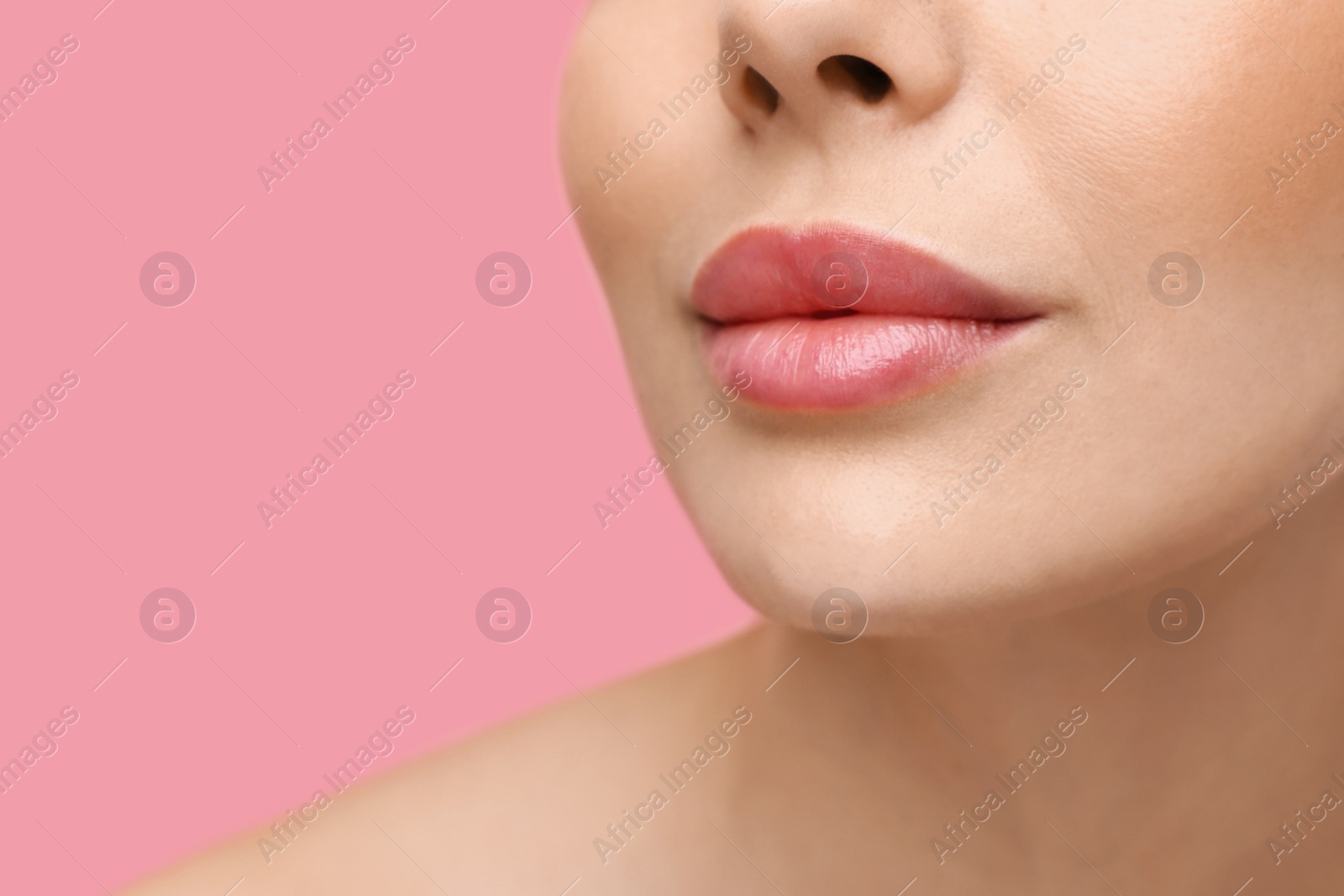 Photo of Woman with beautiful lips on pink background, closeup. Space for text