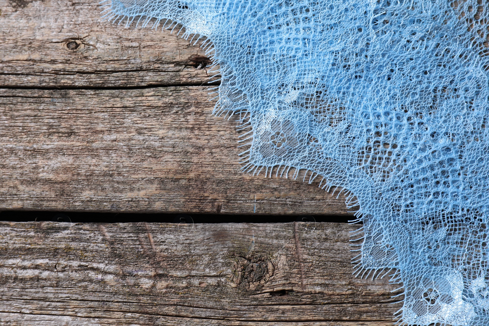 Photo of Beautiful lace on wooden table, top view. Space for text