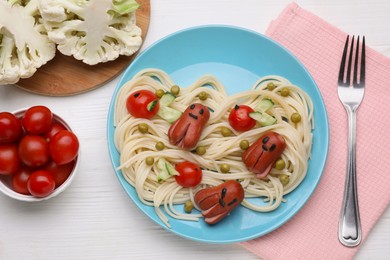Photo of Creative serving for kids. Plate with cute octopuses madesausages, pasta and vegetables on white wooden table, flat lay