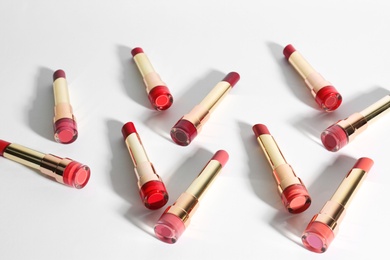 Photo of Set of bright lipsticks in gold tubes on white background