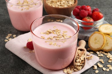 Photo of Glass of tasty berry smoothie with oatmeal on grey table