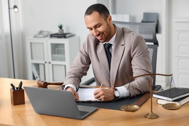 Photo of Smiling lawyer working at table in office