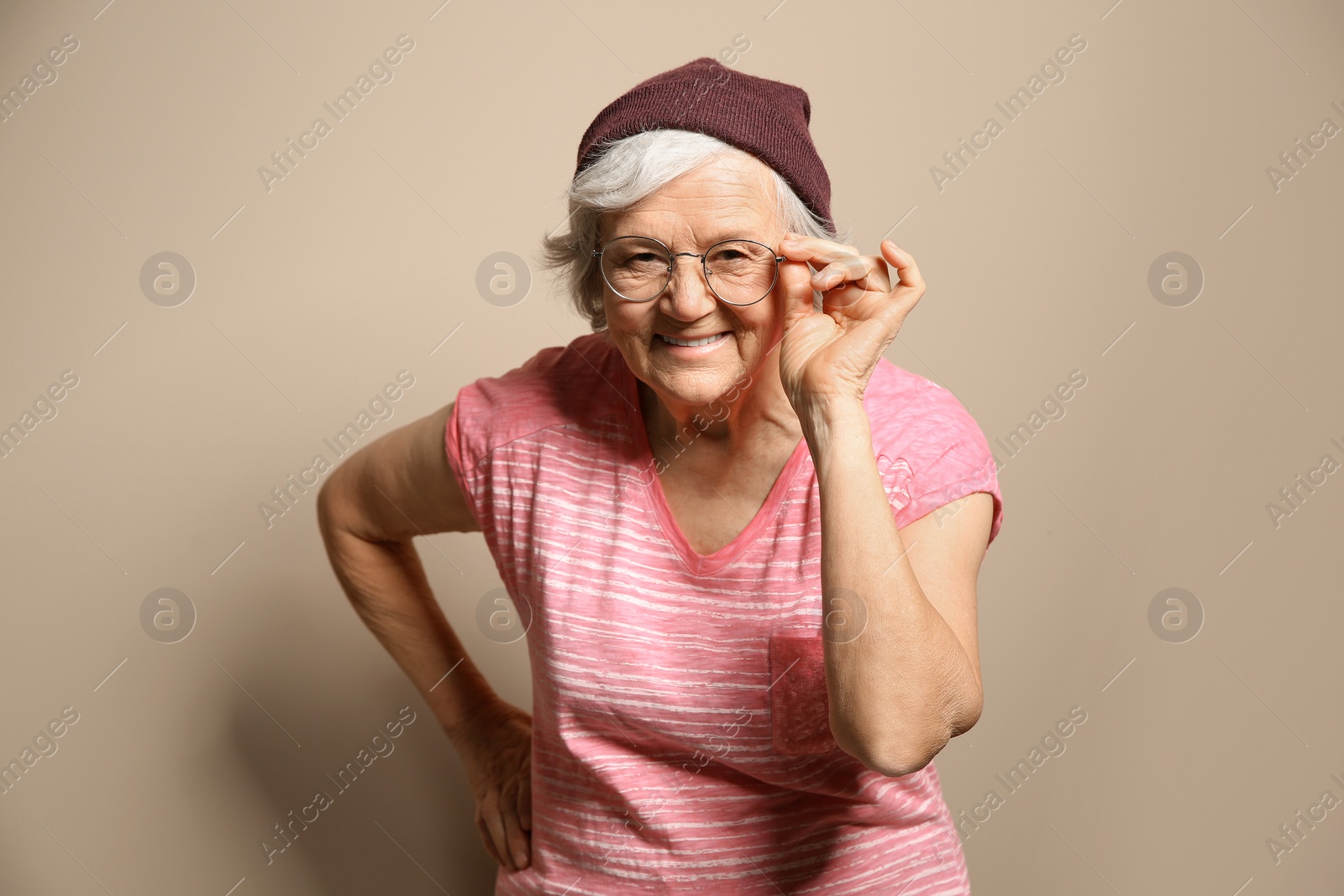 Photo of Portrait of elderly woman in hipster outfit on color background