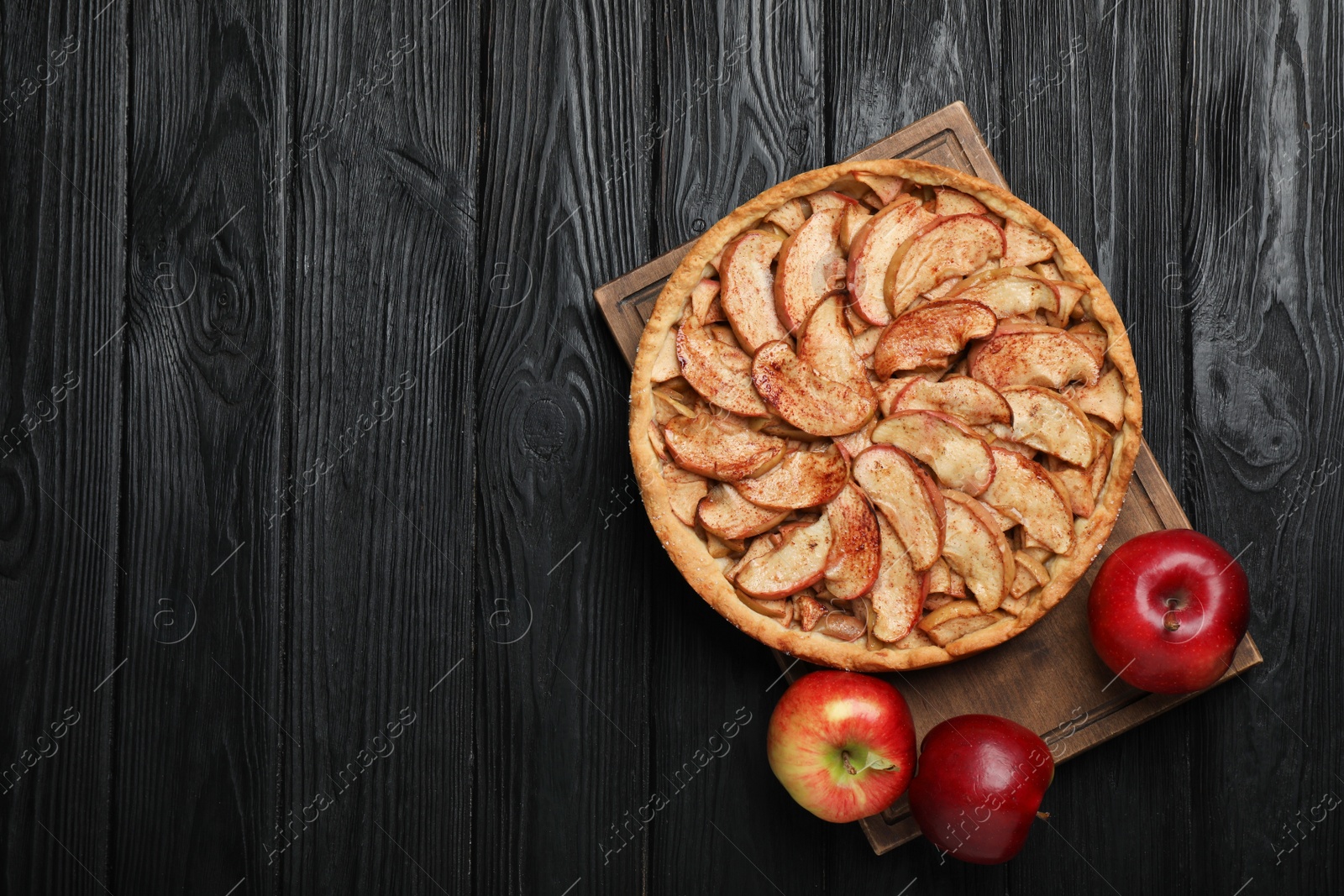 Photo of Delicious apple pie and fresh fruits on black wooden table, top view. Space for text