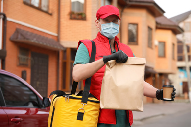 Photo of Courier in protective mask and gloves with orders near car outdoors. Food delivery service during coronavirus quarantine