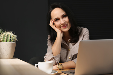 Photo of Beautiful mature woman working with laptop at home