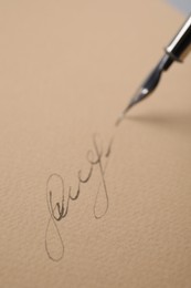 Signing on sheet of paper with fountain pen, closeup
