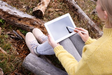 Photo of Woman drawing with graphic tablet outdoors, closeup