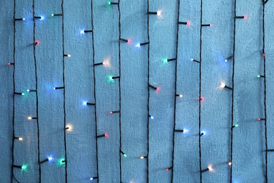 Photo of Beautiful bright Christmas lights on color background