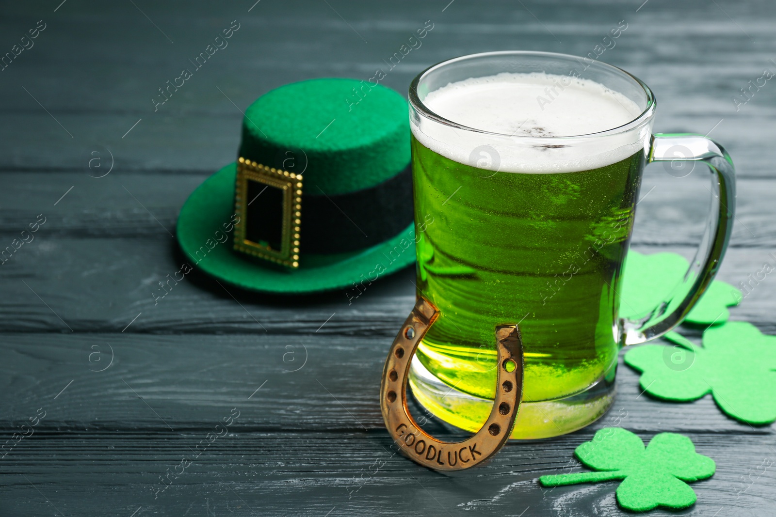 Photo of Composition with green beer and clover leaves on grey wooden table. St. Patrick's Day celebration