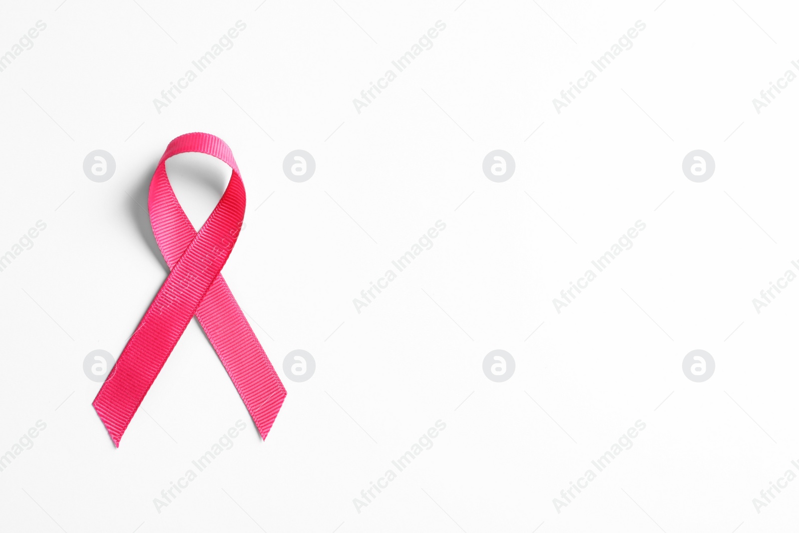 Photo of Pink ribbon on white background, top view. Cancer awareness