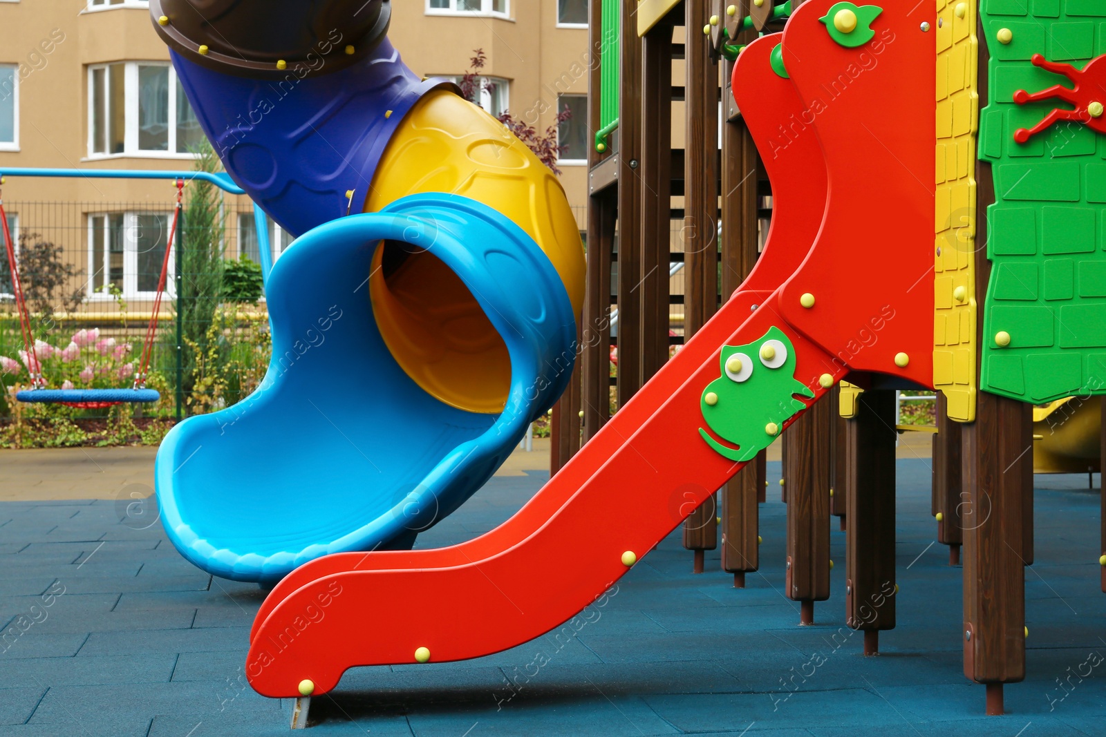 Photo of Colourful slides on outdoor playground for children in residential area