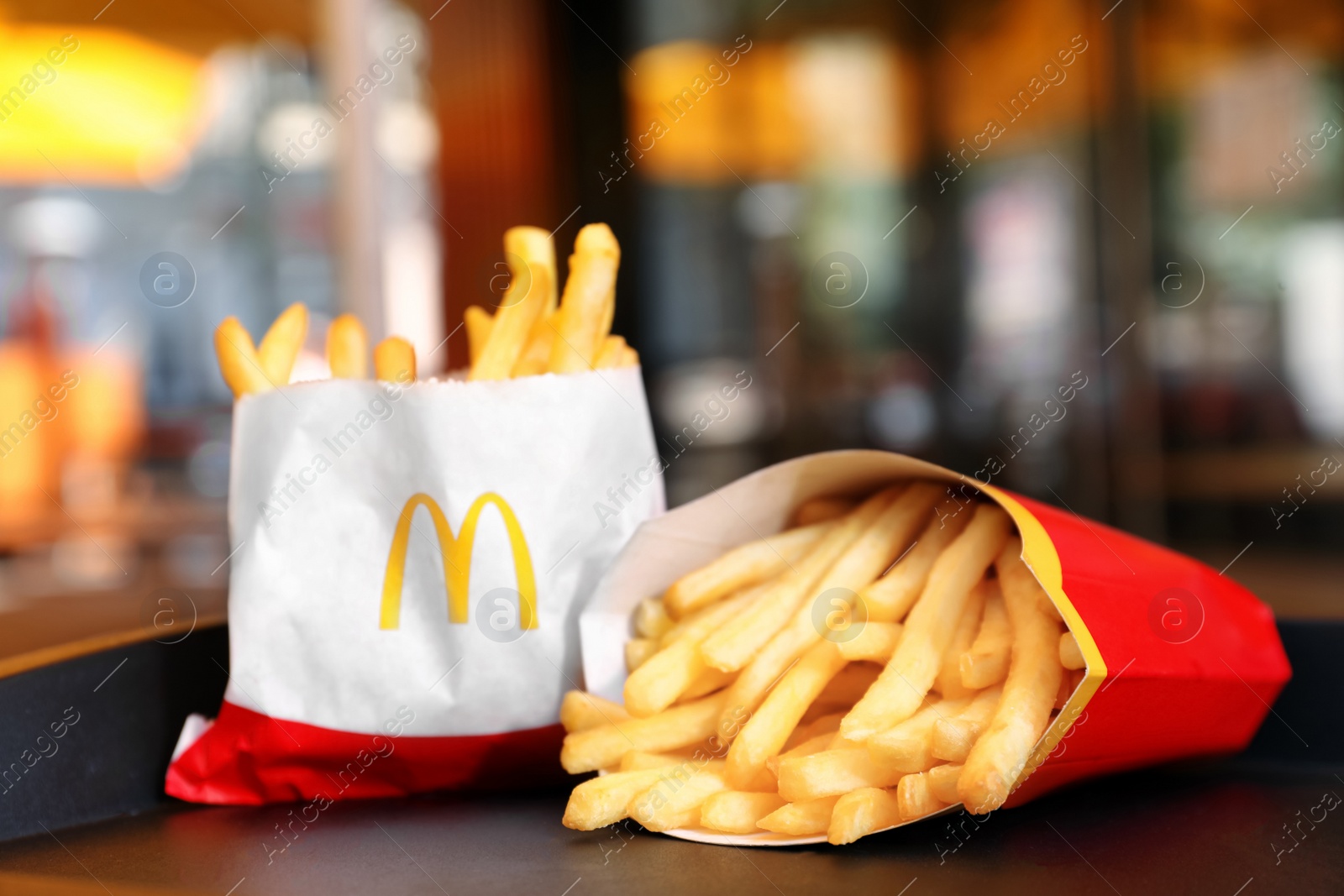 Photo of MYKOLAIV, UKRAINE - AUGUST 11, 2021: Big and small portions of McDonald's French fries on tray in cafe