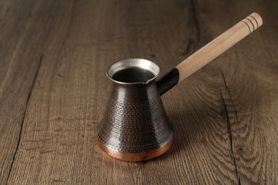 Photo of Copper turkish coffee pot on wooden table