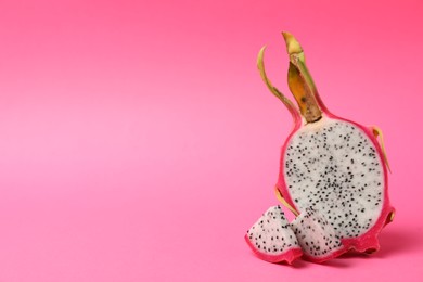 Photo of Delicious cut dragon fruit (pitahaya) on pink background. Space for text