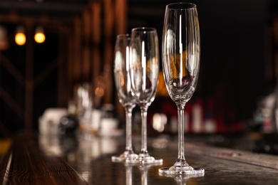 Photo of Empty clean champagne glasses on counter in bar. Space for text