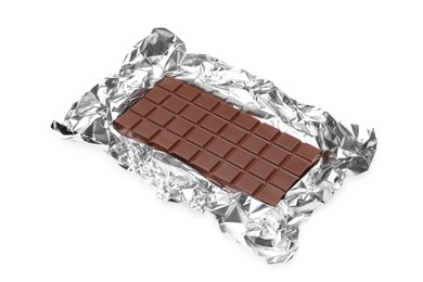 Photo of Delicious milk chocolate bar with foil isolated on white