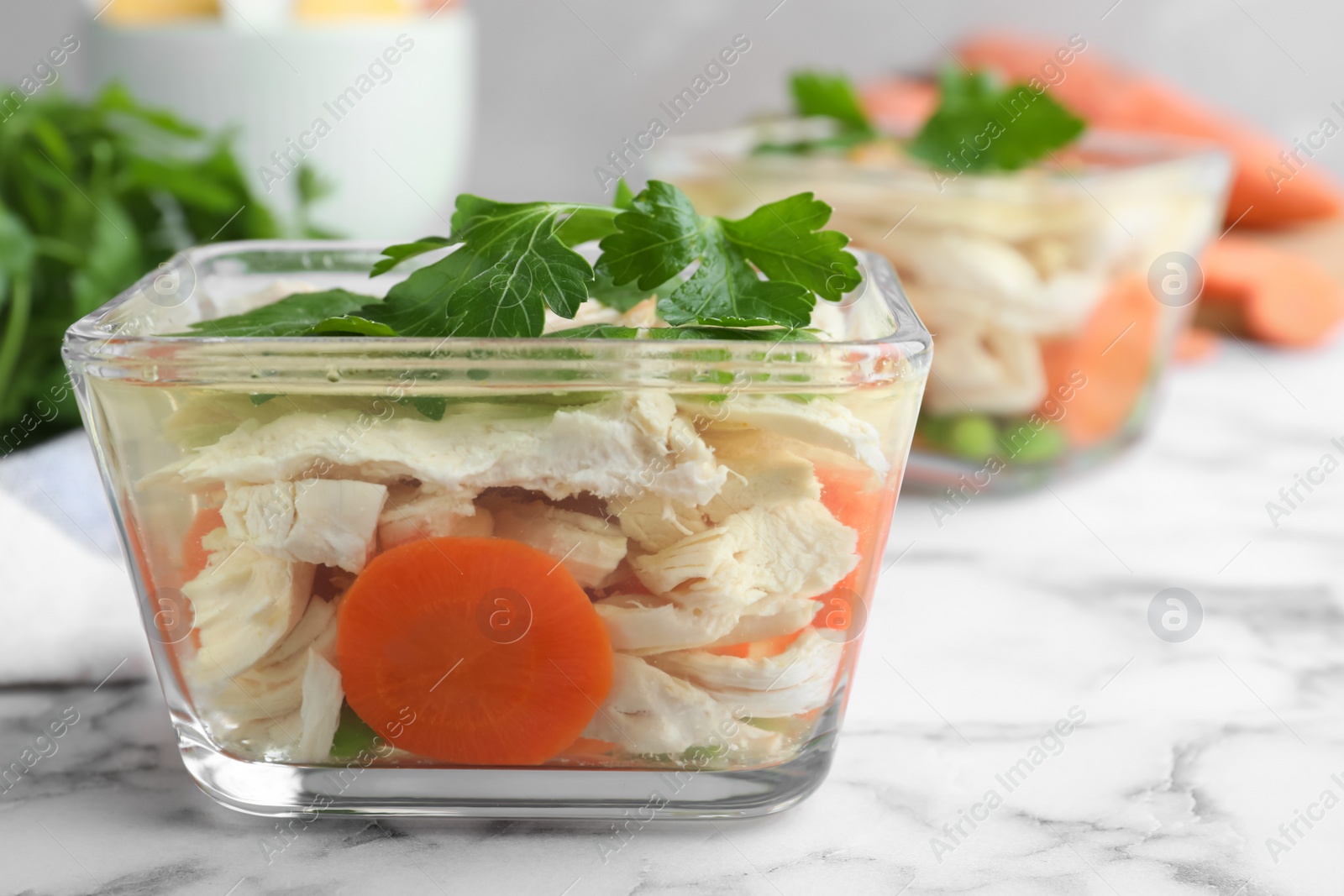 Photo of Delicious chicken aspic served on white marble table, closeup