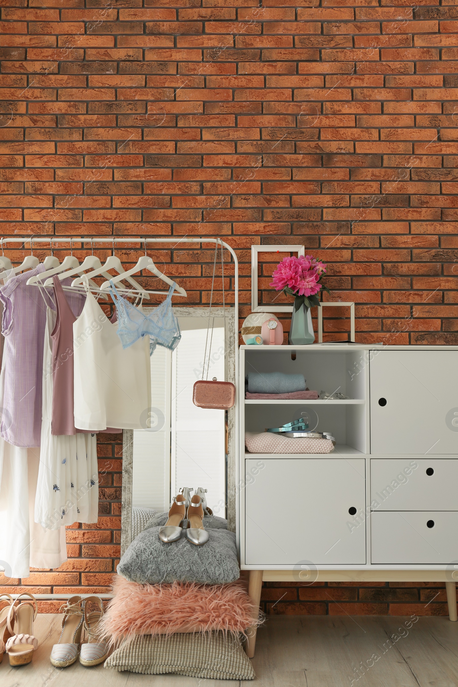 Photo of Stylish dressing room interior with clothes on rack