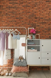 Stylish dressing room interior with clothes on rack