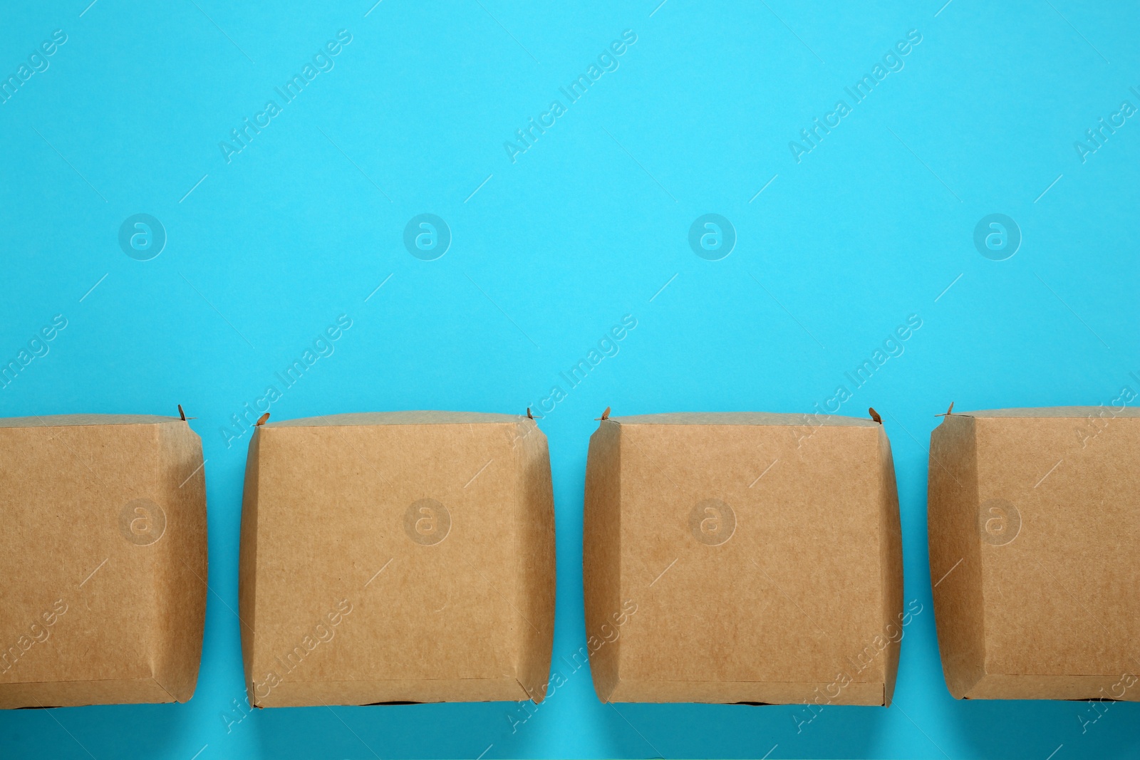 Photo of Flat lay of paper boxes on turquoise background, space for text. Eco friendly lifestyle