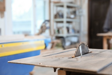 Photo of Carpenter's working place with modern circular saw indoors, space for text