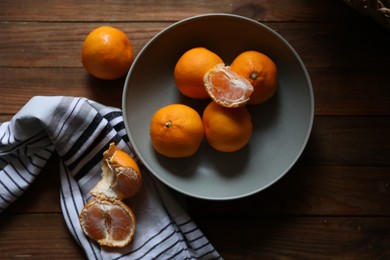 Photo of Fresh ripe tangerines on wooden table, flat lay